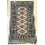 KIRMAN STYLE RUG the green ground centred with a pink and blue lozenge motifs encased by a patterned