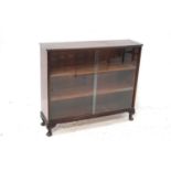 MAHOGANY BOW FRONT BOOKCASE with a pair of glass doors revealing three shelves, standing on stout