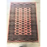 ISHFAN STYLE RUG with a pink ground and lozenge motifs encased by a multi layered border, 186cm x