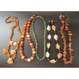FIVE AGATE AND HARDSTONE BEAD NECKLACES of various designs, four in orange and white tones, one with