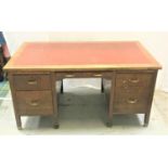 1950'S OAK KNEEHOLE OFFICE DESK with an inset leatherette top above three frieze drawers, two pull