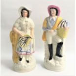 PAIR OF STAFFORDSHIRE FLATBAACK FIGURES of a man and a woman, both holding a basket a fish, 34cm and