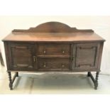 OAK BOW FRONT SIDEBOARD with a shaped and raised back above a moulded top with two central