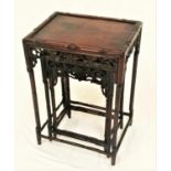 20TH CENTURY ROSEWOOD NEST OF THREE TABLES with rectangular inset tops above a carved and pierced