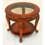 CHERRY CIRCULAR OCCASIONAL TABLE with an inset glass top above a decorative carved frieze,