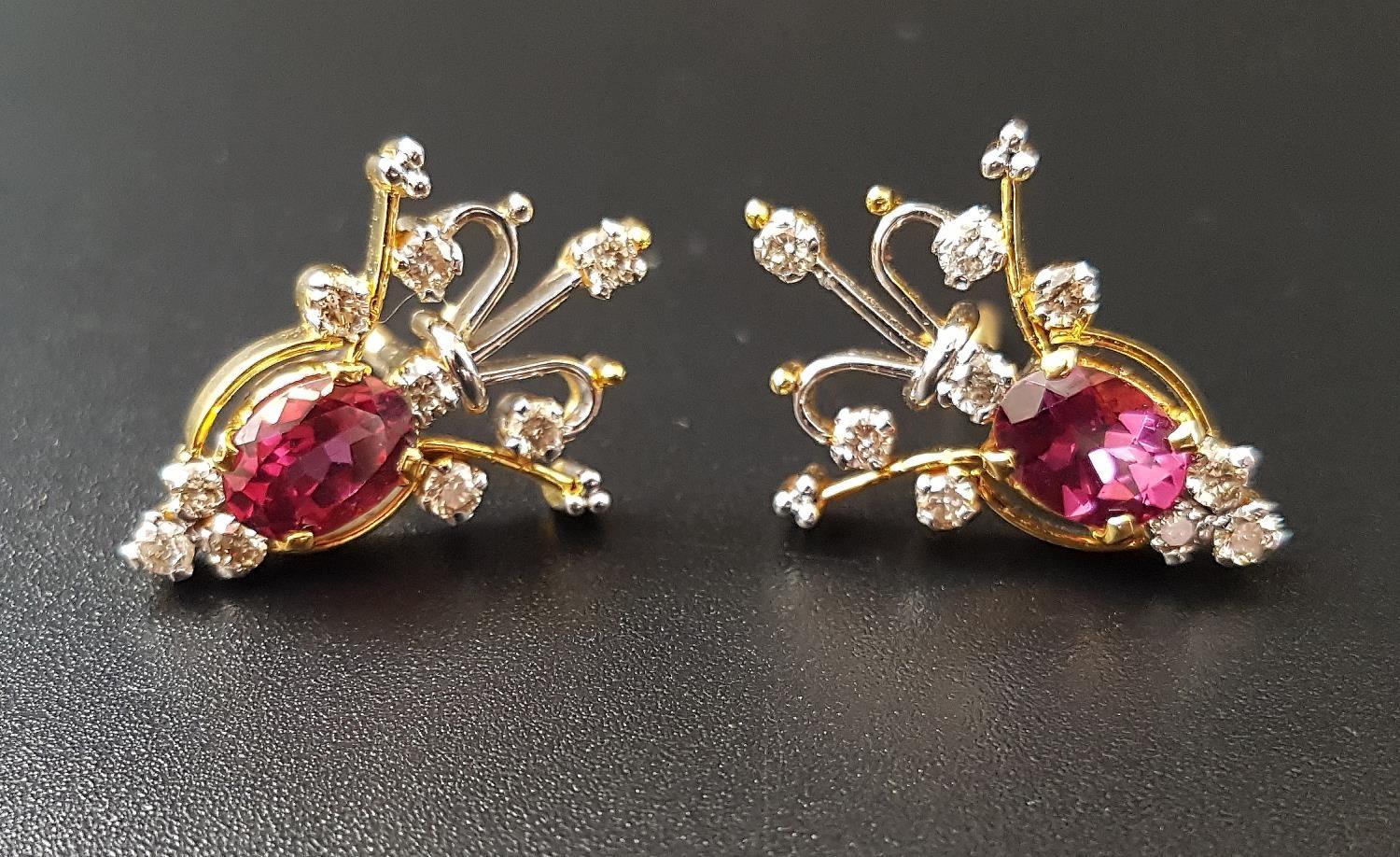 PAIR OF UNUSUAL RUBY AND DIAMOND EARRINGS the central oval cut ruby on each approxmately 0.75cts,