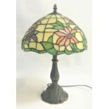 TIFFANY STYLE TABLE LAMP with a floral domed leaded glass shade on a tapering and shaped column with