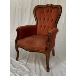 STAINED OAK AND UPHOLSTERED ARMCHAIR with a shaped button back above padded arms with a shaped