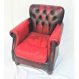 CHESTERFIELD ARMCHAIR in red leather with a button back and decorative metal stud detail, standing