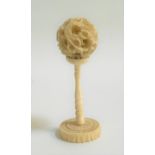 CARVED IVORY PUZZLE BALL with five inner spheres, on a carved stand, 9cm high