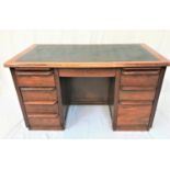 1930s OAK KNEEHOLE DESK with an inset vinyl top above an arrangement of eight drawers and two