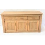 LARGE LIGHT OAK SIDE CABINET with a moulded top above three frieze drawers with three panelled