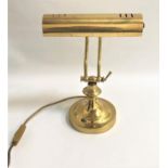 BRASS ADJUSTABLE DESK LAMP raised on a circular base with adjustable arm