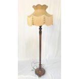 1940'S WALNUT STANDARD LAMP raised on a circular base with shaped feet and tapering column to a