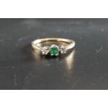 EMERALD AND DIAMOND THREE STONE RING the central emerald approximately 0.2cts flanked by diamonds