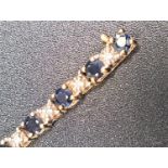 SAPPHIRE AND DIAMOND LINE BRACELET the round cut sapphires separated by small illusion set diamonds,