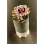 RHODALITE GARNET AND DIAMOND CLUSTER RING the central emerald cut garnet in fourteen diamond