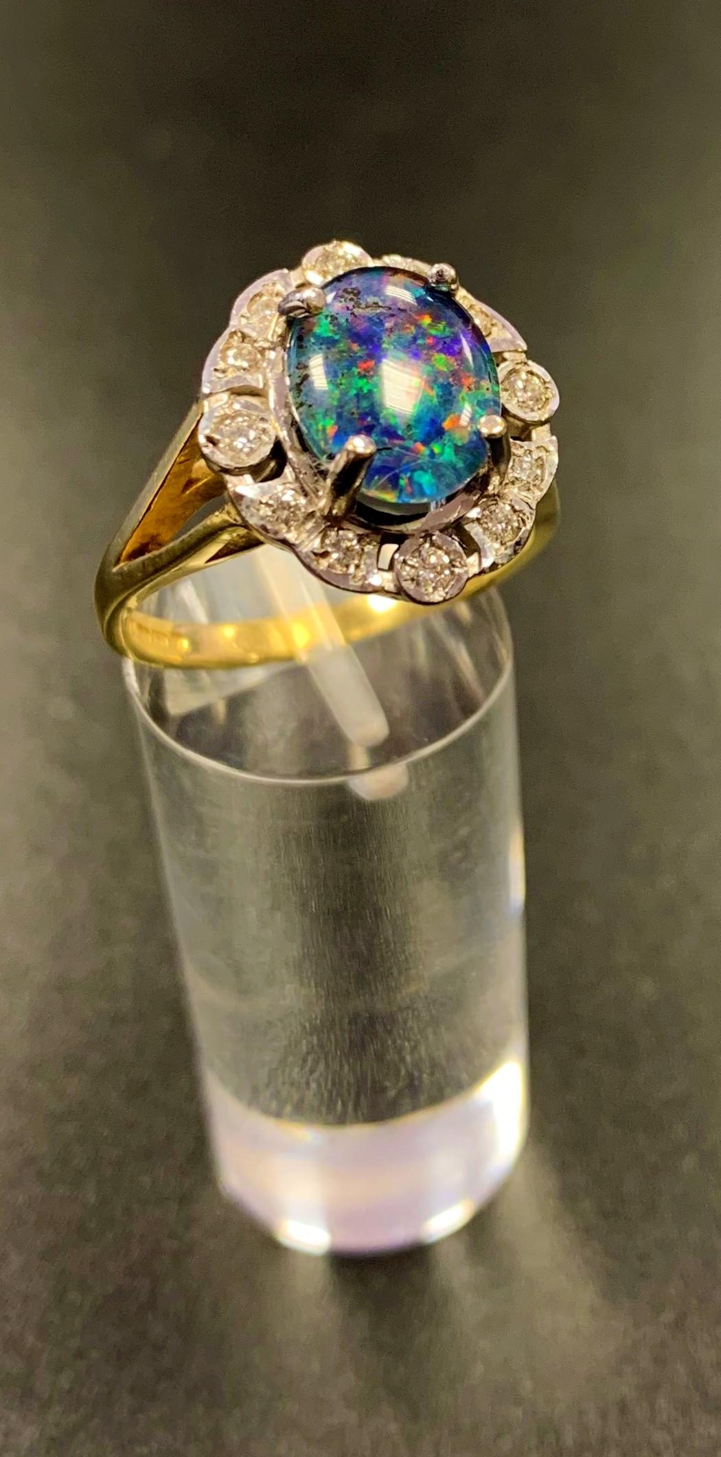 ATTRACTIVE OPAL TRIPLET AND DIAMOND CLUSTER RING the central oval opal triplet in twelve diamond