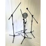 FOUR HERCULES MICROPHONE STANDS all on adjustable tripod supports, one with microphone clip and
