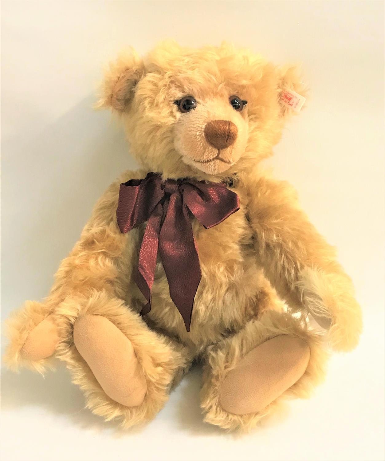 STEIFF GROWLER TEDDY BEAR in golden brown with swivel head and jointed limbs, with burgundy bow