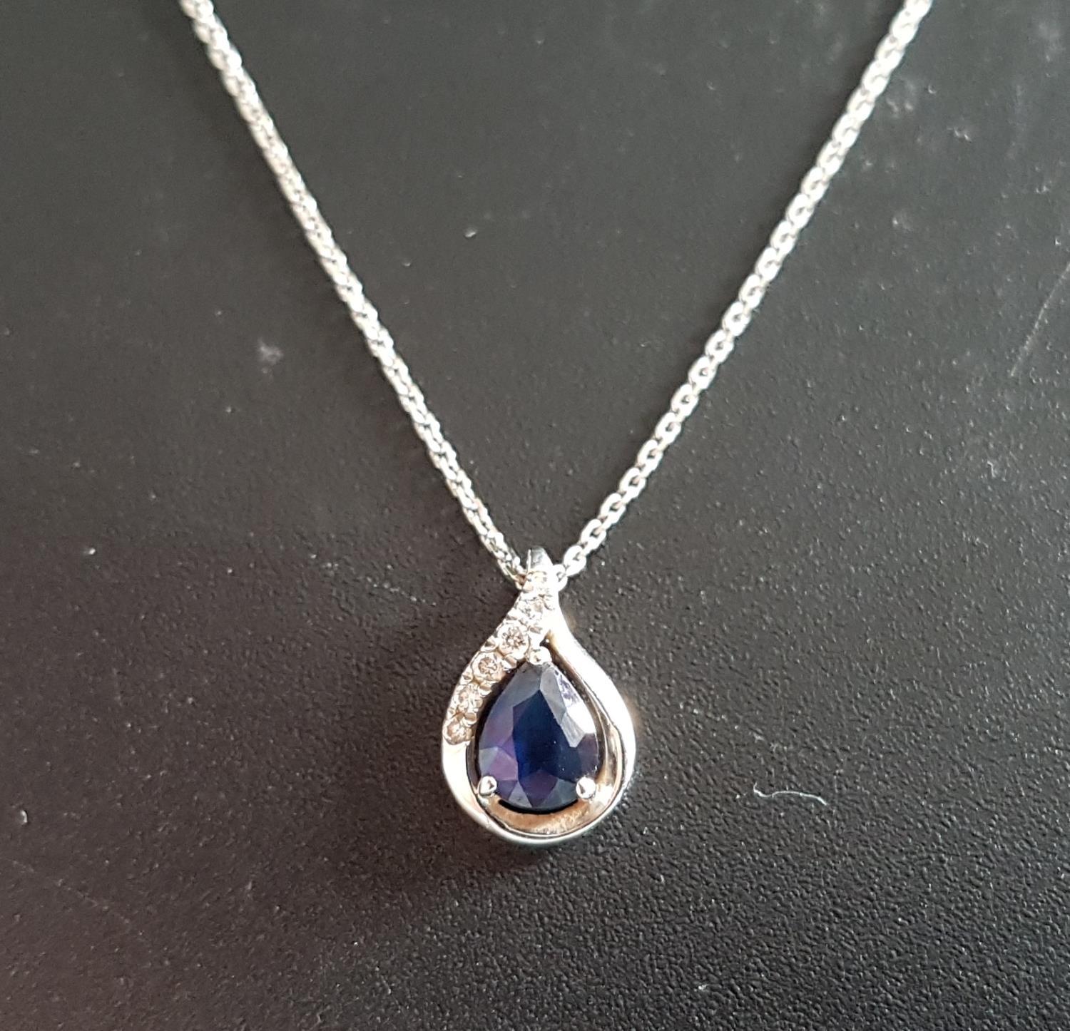 SAPPHIRE AND DIAMOND PENDANT the pear cut sapphire with small diamonds to the nine carat white