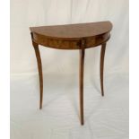 FIGURED WALNUT EFFECT DEMI LUNE SIDE TABLE with two frieze drawers, standing on sabre legs, 59.5cm