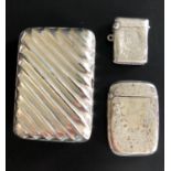 SILVER CIGARETTE CASE AND TWO SILVER VESTA CASES the cigarette case with with ribbed decoration,