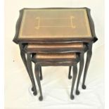 NEST OF MAHOGANY TABLES each with an inset tooled top and glass, standing on slender cabriole