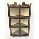 UNUSUAL MAHOGANY CORNER CABINET with a carved pediment above three pairs of glazed doors flanked