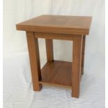 TUCAN FURNITURE TEAK OCCASIONAL TABLE with a square top, standing on plain supports united by an