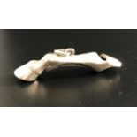 NOVELTY UNMARKED SILVER WHISTLE in the form of a horse's leg, approximately 4.5cm long