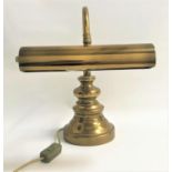 BRASS DESK LAMP raised on a circular stepped base with a shaped arm and tubular adjustable shade,