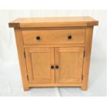 LIGHT OAK SIDE CABINET with an oblong top above a frieze drawer with a pair of panelled cupboard