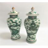 PAIR OF CHINESE FAMILLE VERTE BALUSTER VASES decorated with dragons and foliage, the circular lids