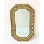 OCTAGONAL WALL MIRROR with a brass embossed frame decorated with shells around a bevelled plate,