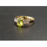 PERIDOT AND DIAMOND RING the central oval cut peridot approximately 1ct flanked by two small