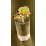 OPAL AND DIAMOND CLUSTER RING the central round cabochon opal in fourteen diamond surround, on