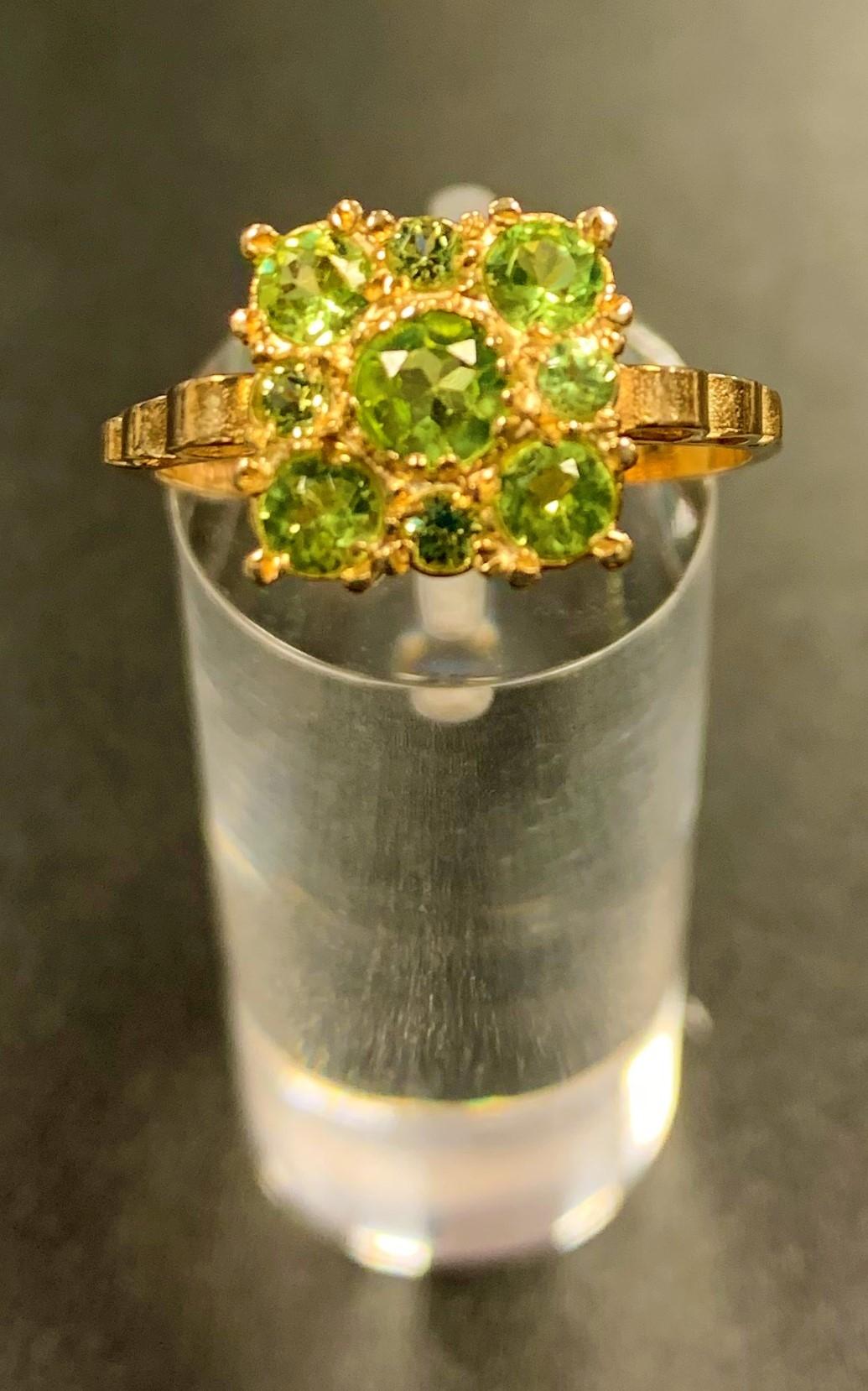 PERIDOT CLUSTER RING the nine peridots of varying size in square setting, on nine carat gold