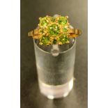 PERIDOT CLUSTER RING the nine peridots of varying size in square setting, on nine carat gold