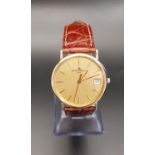 GENTLEMEN'S BAUME & MERCIER EIGHTEEN CARAT GOLD CASED WRISTWATCH the gilt dial with baton five