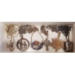 SIX SILVER PENDANTS ON SILVER CHAINS of various designs, including an Aires pendant, a filigree