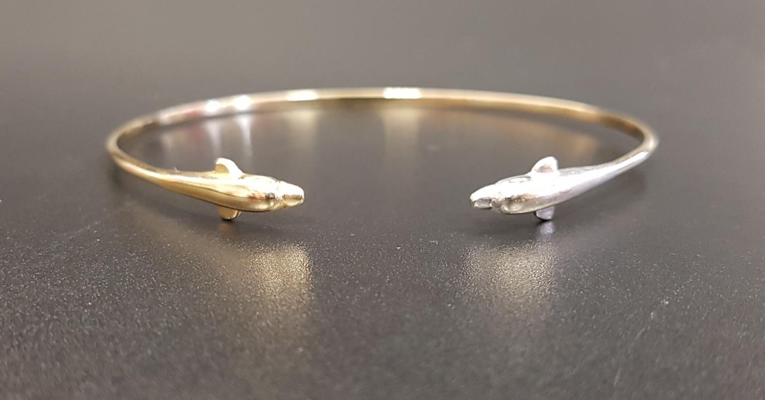 FOURTEEN CARAT GOLD BANGLE with dolphin finials, one in white gold and the other yellow,