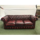 CHESTERFIELD THREE SEAT SOFA in deep red leather with button back, arms and front, with decorative