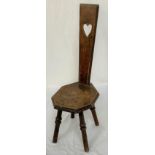 OAK SPINNING CHAIR with a tapering narrow back with a pierced heart motif above a shaped seat,