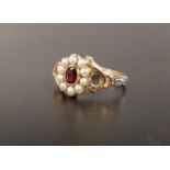 GARNET AND SEED PEARL CLUSTER RING the central oval cut garnet in ten pearl surround, flanked by