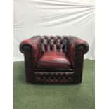 CHESTERFIELD ARM CHAIR in deep red leather with a button back, arms and front, with decorative metal
