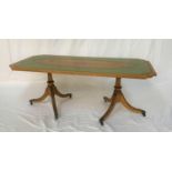 OBLONG MAHOGANY OCCASIONAL TABLE with an inset green leather top, standing on twin turned columns,