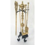 DECORATIVE BRASS COMPANION SET with a knopped stand raised on four iron scroll supports, with a