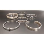 SIX SILVER BANGLES of various sizes and designs including two Charles Rennie Mackintosh style