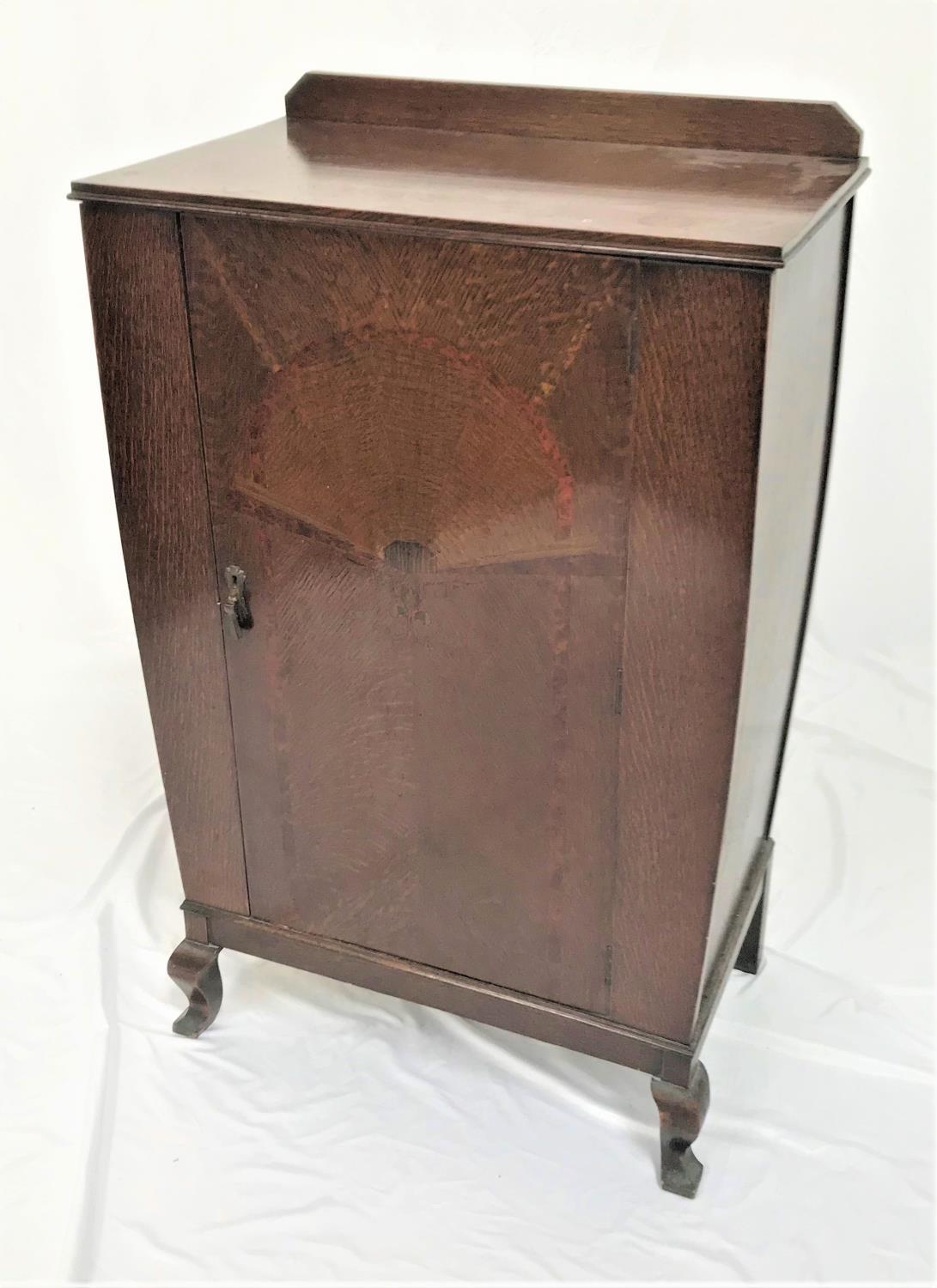 OAK CUPBOARD with a shaped raised back above an inlaid cupboard door opening to reveal shelves,